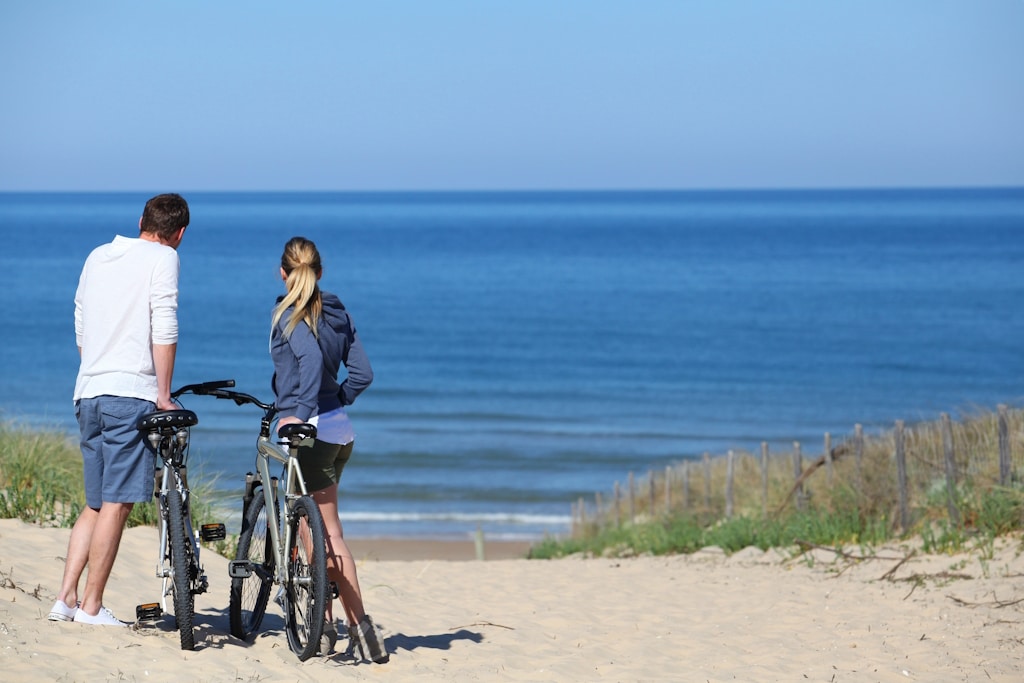 Couple,With,Bicycles,Looking,At,The,Ocean