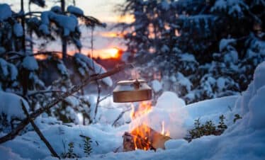 Kocher und Zelt im Winter in Finnland
